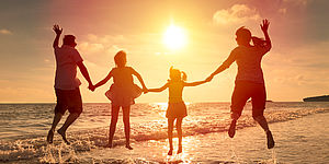 Foto famiglia al tramonto sulla spiaggia