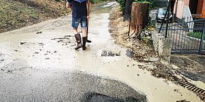 Uomo che cammina nel fango con ombrello