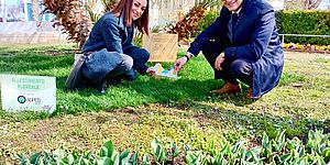 Murgia e Pieri in un prato con cartello "Giardino della nuova vita"