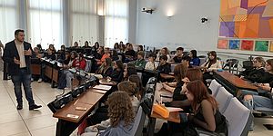 Ragazzi seduti in sala Consiglio con al centro Perugini