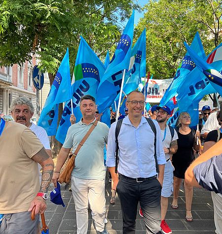 Ricci con alle spalle le bandiere del sindacato