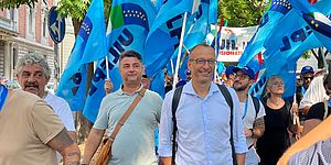 Ricci con alle spalle le bandiere del sindacato