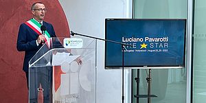 Ricci sul palco con cartello "Luciano Pavarotti"
