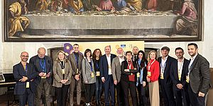 Gruppo partecipanti con sopra dipinto dell'ultima cena