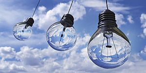 Tre lampadine trasparenti appese nel cielo tra le nuvole