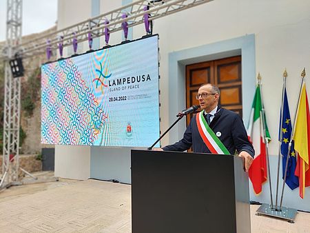 Sindaco con scritta Lampedusa alle spalle