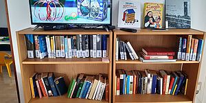 libreria con libri e sopra televisione