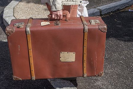 Immagine di valigia tenuta da una mano maschile
