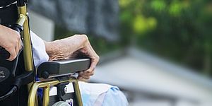 particolare sedia a rotelle con braccio anziana