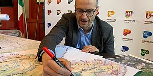 Ricci che indica una cartina delle Marche