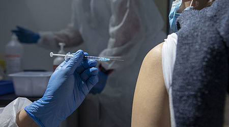 siringa che sta iniettando un vacino