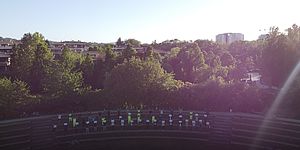 Persone nell'anfiteatro del Miralfiore con cartello 