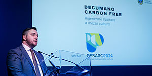 Perugini con dietro immagine di "Città in scena"