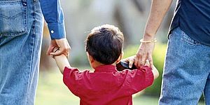 adulti con per mano un bimbo