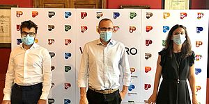 Mengucci Pozzi Ricci davanti al cartellone con i city brand