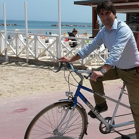 Biancani in bici con dietro spiaggia