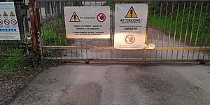 Cancello con cartelli "bonifica amianto"