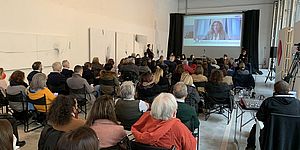 Nello schermo il ministro Stefani con platea