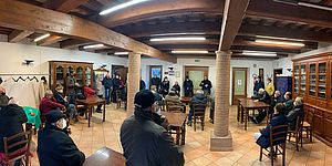 Sindaco e anziani seduti ai tavolini distanziati