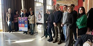 Foto di gruppo con assessore Vimini e manifesto dell'evento