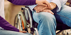 Mani e persona sulla sedia a rotelle