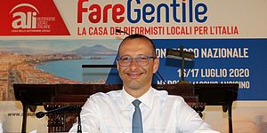 Ricci davanti al cartellone "Fare gentile"