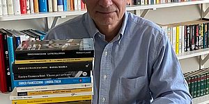 Enrico Franceschini con davanti pila di libri