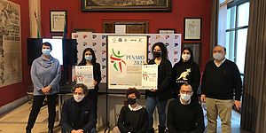 Ricci ed altri attorno al manifesto con il logo della ginnastica