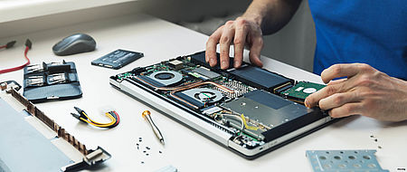 Mani che lavorano a sistemare un PC