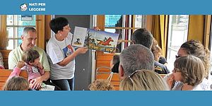 Signora che legge bambini e persone che ascoltano