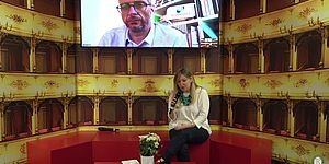 Ricci sullo schermo del PC con sullo sfondo teatro e condutrice