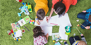 Bambini che disegnano sopra il prato