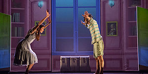 ragazzo e ragazza con le mani in alto in una cameretta/palcoscenico