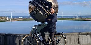 Livio Leonardi in bici davanti alla Sfera grande di Pomodoro