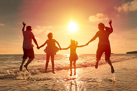 Foto famiglia al tramonto sulla spiaggia