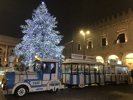 trenino in piazza con albero illuminato