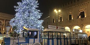 trenino in piazza con albero illuminato
