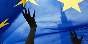 particolare bandiera europea con delle mani che la sorreggono