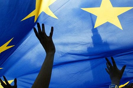 particolare bandiera europea con delle mani che la sorreggono