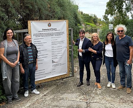 Biancani ed altri al cancello della via