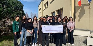 Frenquellucci Murgia con ragazze dell'università di Pesaro Studi con in mano un maxi assegno