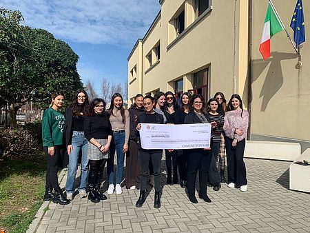 Frenquellucci Murgia con ragazze dell'università di Pesaro Studi con in mano un maxi assegno